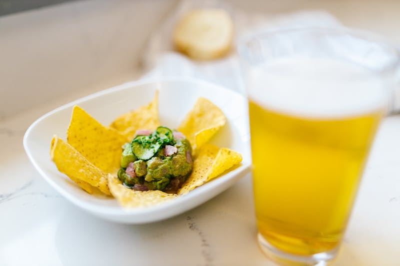 Cheesy dip bowl with tortilla chips and jalapeños